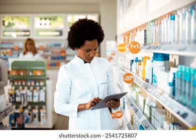 Female pharmacist using tablet for inventory check at pharmacy drugstore - Powered by Shutterstock