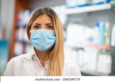 Female Pharmacist Wearing A Coronavirus Covid Mask While Standing In Her Pharmacy