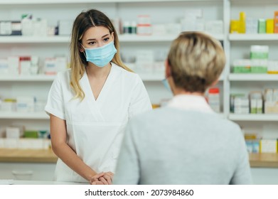 Female Pharmacist Wearing Protective Mask And Serving A Customer Patient In A Pharmacy