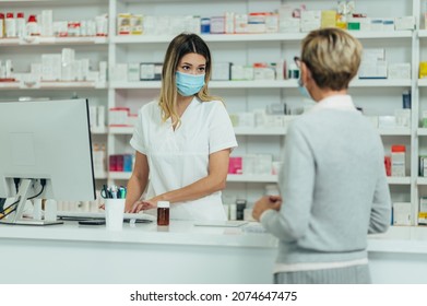 Female Pharmacist Wearing Protective Mask And Serving A Customer Patient In A Pharmacy