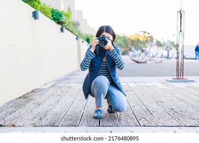 Female Photographer Crouching And Taking Pictures