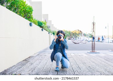 Female Photographer Crouching And Taking Pictures