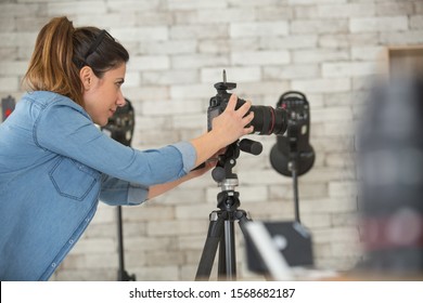 Fotografin, die eine Kamera im Studio aufstellt