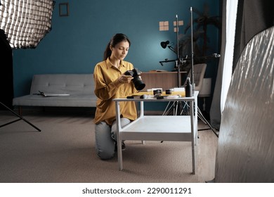 Female photographer shooting beauty cosmetics products on the table at home studio. Copy space - Powered by Shutterstock