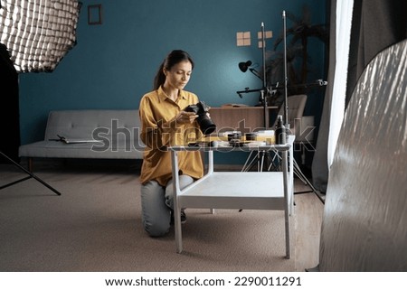 Female photographer shooting beauty cosmetics products on the table at home studio. Copy space