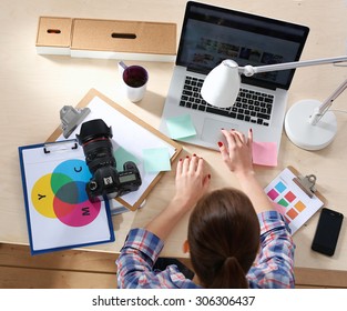 Female photographer sitting on the desk with laptop - Shutterstock ID 306306437