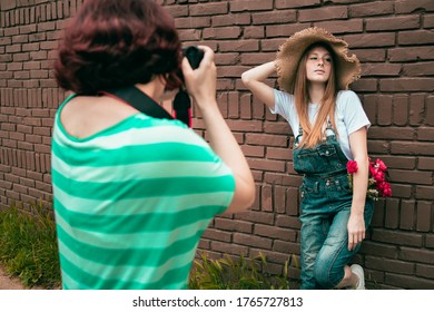 Female Photographer Taking Photos Of Beautiful Teen Ginger Girl. Outdoors Shooting, Natural Light