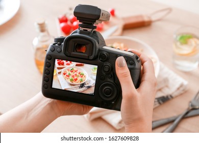 Female photographer taking picture of pasta on table - Powered by Shutterstock