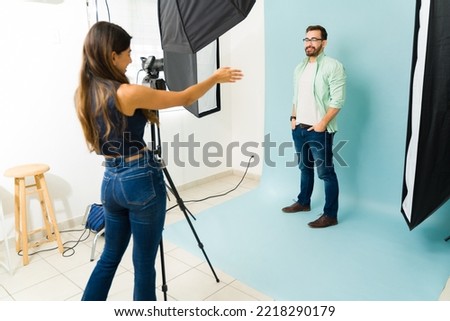 Female photographer talking with a caucasian male poodle position during a fashion photoshoot