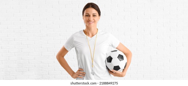 Female Physical Education Teacher With Ball On White Brick Background