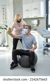 Female Physical Therapist Working With Senior Man 