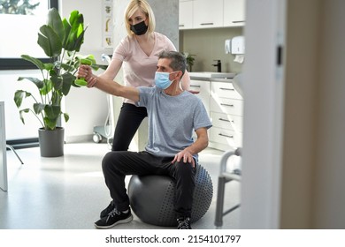 Female Physical Therapist Working With Senior Man 