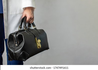 Female Physician Holding A Black Leather Doctor's Bag Heading To The Office To Practice Medicine