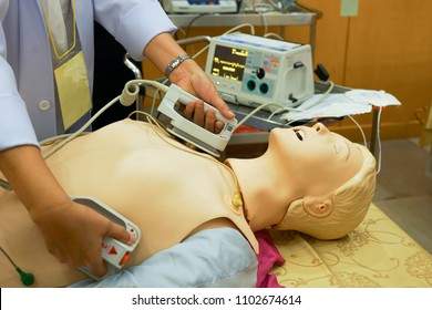 A Female Physician Performning Cardioversion With Defibrillator On A Mannequin During Advance Cardiac Life Support Course Training                               