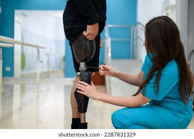 Female physiotherapist adjusting prosthetic leg of patient in hospital - Powered by Shutterstock