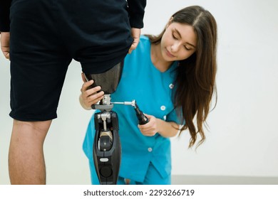 Female physiotherapist adjusting prosthetic leg of patient in hospital - Powered by Shutterstock