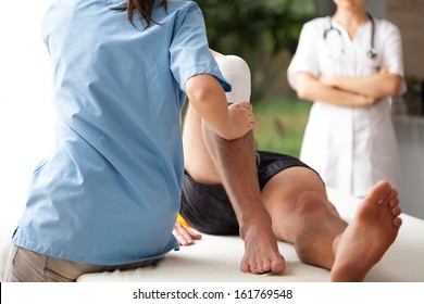Female physiotherapist helping to exercise the patient injured knee