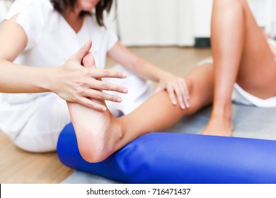 Female physiotherapist inspecting her patient. Medical check at the legs in a physiotherapy center. - Shutterstock ID 716471437
