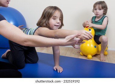 a female physiotherapist makes physiotherapy with young children