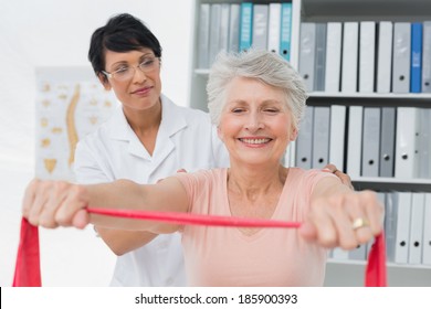 Female physiotherapist massaging senior womans back in the medical office - Powered by Shutterstock