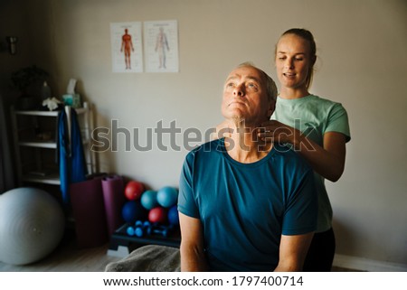 Similar – Image, Stock Photo A female physiotherapist performs stretches on the neck of her patient, an elderly man, to aid in his rehabilitation and wellbeing