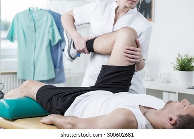 Female physiotherapist training leg of young man - Powered by Shutterstock