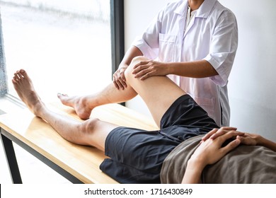 Female Physiotherapist working examining treating injured leg of male patient, Doing exercises the Rehabilitation therapy pain his in clinic.