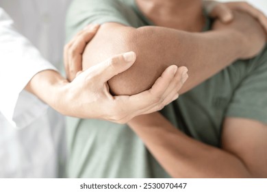 Female physiotherapists provide assistance to male patients with elbow injuries examine patients in rehabilitation centers. Physiotherapy concepts. - Powered by Shutterstock