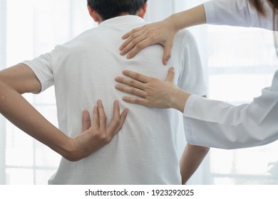 Female physiotherapists provide physical assistance to male patients with back injuries back massages for relaxation and muscle recovery in the rehabilitation center.