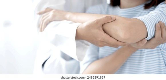 Female physiotherapists provide physical assistance to women patients with elbow injuries examine patients in rehabilitation centers. Physiotherapy concepts. - Powered by Shutterstock