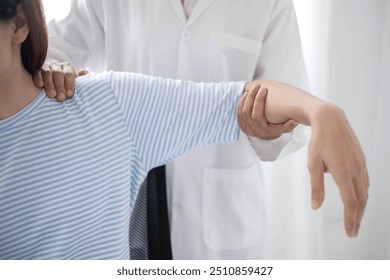 Female physiotherapists provide physical assistance to patients with shoulder injuries massaging their shoulders for muscle recovery in the rehabilitation center. Physiotherapy concepts. - Powered by Shutterstock