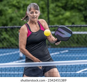 Female pickleball player about to strike a volley  - Powered by Shutterstock