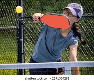 Female pickleball player prepares to block volley the pickleball - Shutterstock ID 2191354291