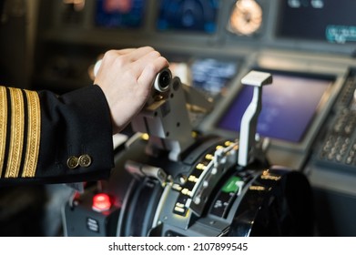 Female pilot's hand on the plane engine control stick.