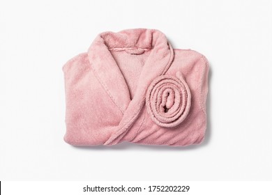 Female pink bathrobe neatly folded on a white background. Copy space, flat lay