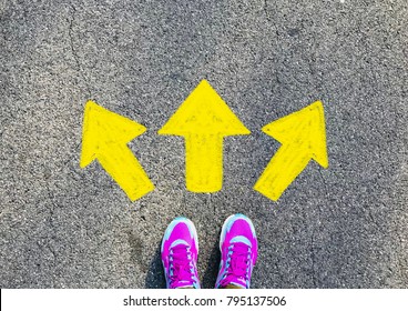 Female pink sport shoe with yellow drawn direction  arrow as guidance, top view. Young street lifestyle, which way your choice - Shutterstock ID 795137506