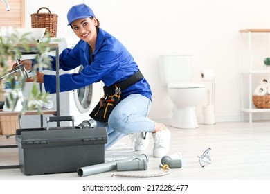 Female Plumber Fixing Sink In Bathroom