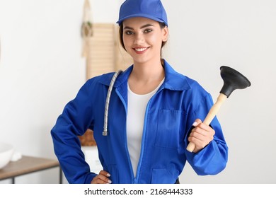 Female Plumber With Plunger In Bathroom