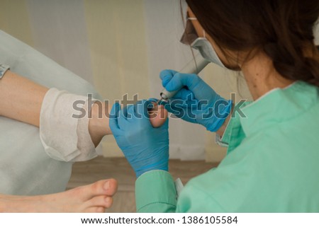 Female podologist doing a medical pedicure. Foot care. 