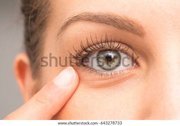 Female pointing eye bag with\
finger