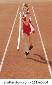 Female Pole Vaulter Running With Pole On Track And Field