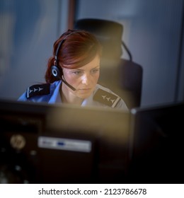 Female Police Officer In A Call Center, Listening Carefully To An Emergency Call From A Person In Distress