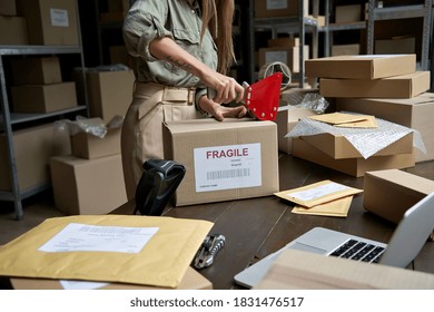 Female post mail storage worker holding tape dispenser sealing shipping online store order courier delivery cardboard box packing ecommerce fragile dropshipping parcel in distribution warehouse.