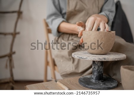 female potter creates handmade handicrafts. Close-up of hands sculpting a clay bowl on a working table in a ceramics studio in a workshop. artistic concept. copy space.