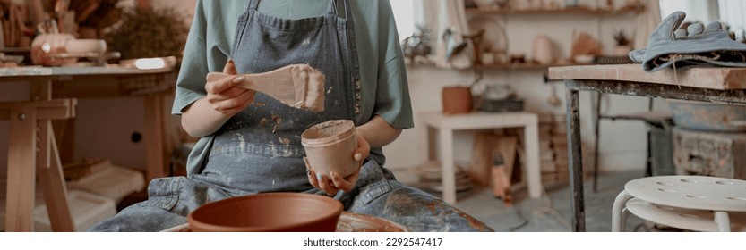 Female potter making earthenware in pottery workshop - Powered by Shutterstock