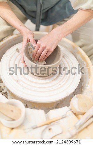 Similar – Young female sitting by table and making clay or ceramic mug