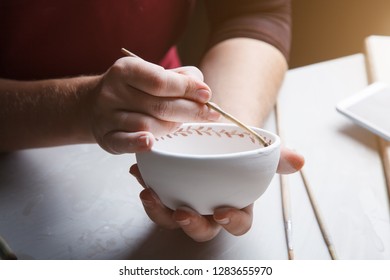 Female Potter Painting White Ceramic Bowl 