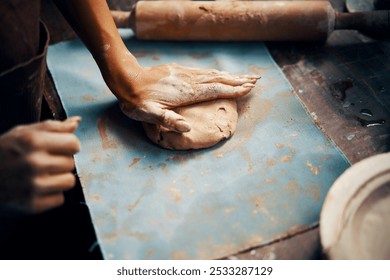 Female potter sculpts from clay at her workshop. raw clay shaping process close-up, top view. Mastering the art of pottery craft ceramics - Powered by Shutterstock