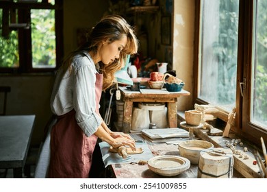 Female potter sculpts from clay at her workshop. raw clay shaping process close up. Mastering the art of pottery craft ceramics - Powered by Shutterstock