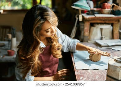 Female potter sculpts from clay at her workshop. raw clay shaping process close up. Mastering the art of pottery craft ceramics - Powered by Shutterstock